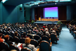 Image: Speaker giving a presentation in an auditorium